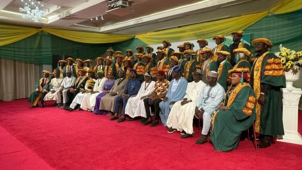 Engineers and dignitaries in ceremonial academic robes pose for a group photograph at a professional fellowship event in Lagos.